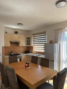 a kitchen with a wooden table and a refrigerator at CHATA u BABULŮ in Morávka