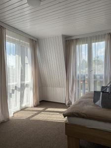 a bedroom with a bed and large windows at CHATA u BABULŮ in Morávka