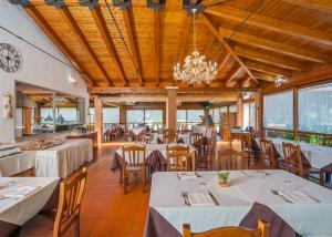 a restaurant with tables and chairs and a chandelier at Agriturismo Parmenide in Castelnuovo Cilento