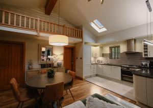 a kitchen and living room with a table and chairs at Noble Fir Lodge - The Hollies Retreats in Oakmere