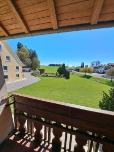 a bench on a balcony with a view of a yard at Gästehaus Kienle in Rot an der Rot