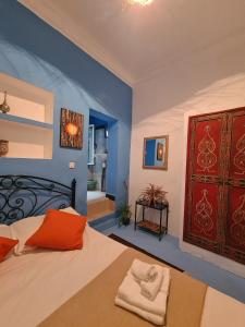 a bedroom with a bed and a blue wall at La Joya Hostel Chafchaouen Cozy Stay with Terrace in Chefchaouen