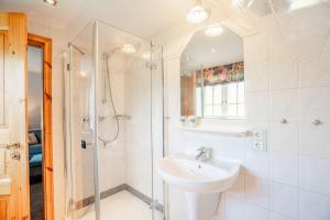 a white bathroom with a sink and a shower at Haus-Margarete-Nordwind in Kampen +23 photos