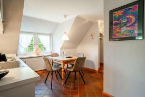 a kitchen and dining room with a table and chairs at Haus-Margarete-Nordwind in Kampen