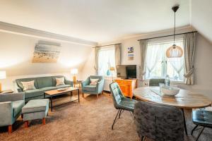a living room with a couch and a table and chairs at Haus-Margarete-Westwind in Kampen