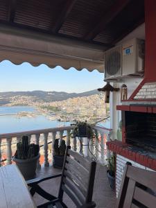 a balcony with a table and chairs and a view of the water at Saguaro’s home Kavala in Kavála