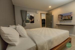 a bedroom with a bed with white sheets and pillows at กบอุทัย รีสอร์ท in Ban Don Khwang
