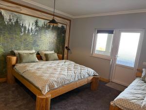 a bedroom with a bed and a painting on the wall at GB Cazare in Volovăţ +8 photos