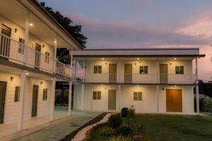 a large white house with a courtyard at กบอุทัย รีสอร์ท in Ban Don Khwang