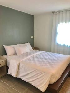 a large bed in a bedroom with a window at กบอุทัย รีสอร์ท in Ban Don Khwang