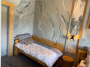 a bed in a room with a wall at GB Cazare in Volovăţ