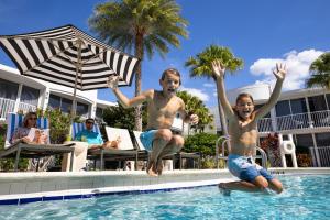 a man and a young boy jumping into a swimming pool at Renaissance Orlando Resort - Disney Springs Area - Free Shuttle & Early Entry to Disney Theme Parks in Orlando