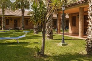 a park with a bench and palm trees in front of a building at Grand Hotel Vigna Nocelli in Lucera