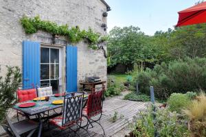 a patio with a table and chairs on a deck at Gîte Le Gué De Champagné in Torxé