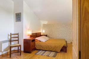 a bedroom with a bed and a table and a chair at Gîte Le Gué De Champagné in Torxé