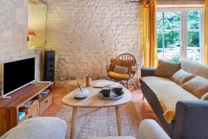 a living room with a couch and a table at Gîte Le Gué De Champagné in Torxé