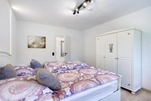 a bedroom with a bed and a white cabinet at Feriennest Balve in Balve +37 photos