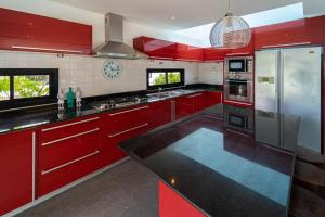 a kitchen with red cabinets and a refrigerator at Malee Beach F1 in Phra Ae beach