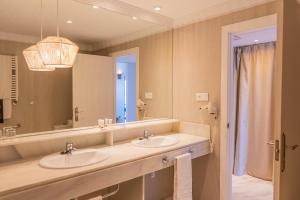 a bathroom with two sinks and a large mirror at ALEGRIA Costa Ballena Aquafun & Spa in Costa Ballena