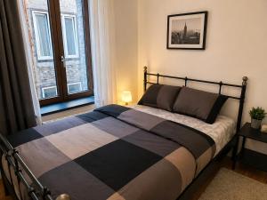 a bed in a bedroom with a large window at Appartement bien-être in Liège