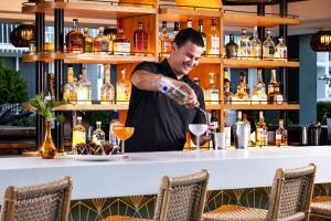 a man pouring a drink at a bar at Renaissance Orlando Resort - Disney Springs Area - Free Shuttle & Early Entry to Disney Theme Parks in Orlando