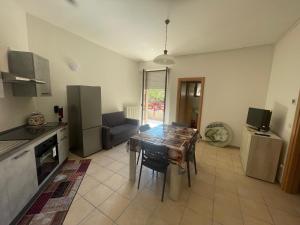 a kitchen with a table and a dining room at Apartament 2 bedroom with one bathroom and penthouse Apartament 3 bedroom and 2 bathroom included with umbrella and sunbeds in Lido Adriano
