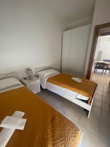 a bedroom with two beds and a balcony at Apartament 2 bedroom with one bathroom and penthouse Apartament 3 bedroom and 2 bathroom included with umbrella and sunbeds in Lido Adriano