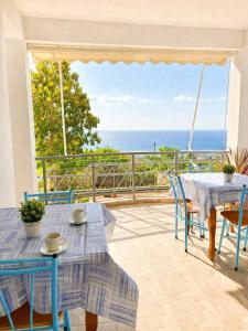 a patio with tables and chairs and a view of the ocean at Dagos Rooms in Dhërmi