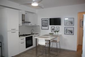 a white kitchen with a table and chairs in it at Casa Bruna in Levanto