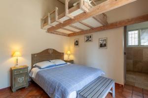 a bedroom with a blue bed with a bench in it at Chambre D'hôtes Les 5 Calanques in Ensuès-la-Redonne