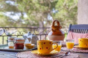 a table with cups and plates of food and a kettle at Chambre D'hôtes Les 5 Calanques in Ensuès-la-Redonne +13 photos