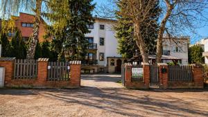 a brick fence in front of a white house at For rest Hostel in Lublin