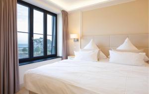a bedroom with a white bed with a large window at Prince in Binz