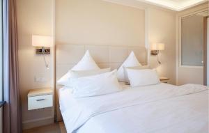 a bedroom with a white bed with white pillows at Prince in Binz