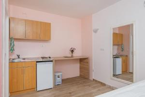 a kitchen with wooden cabinets and a white refrigerator at Apartments Giardino Mediterraneo in Petrovac na Moru