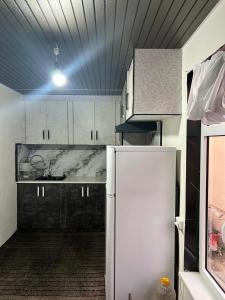 a kitchen with white cabinets and a white refrigerator at Shahzod Guesthouse & Homestay in Gelen +21 photos