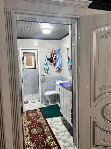 a bathroom with a shower and a toilet and a sink at Shahzod Guesthouse & Homestay in Gelen