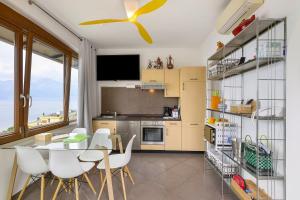 a kitchen with a dining table and a ceiling fan at Residence La Mignon Oleandri in Torri del Benaco +18 photos
