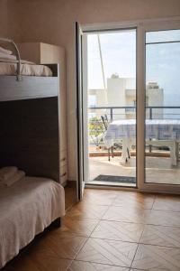 a bedroom with a bed and a sliding glass door at Dagos Rooms in Dhërmi