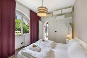 two beds in a room with two windows at Residence La Mignon Oleandri in Torri del Benaco