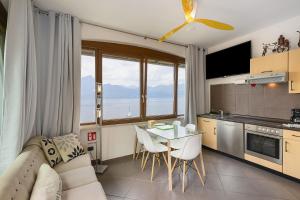 a living room with a couch and a table with chairs at Residence La Mignon Oleandri in Torri del Benaco