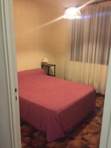 a bedroom with a red bed and a window at vigne maio in Ventiseri +2 photos
