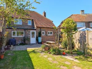 a garden in front of a brick house at Pickleberry Cottage - Close to sandy beach in West Wittering