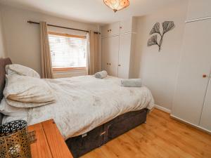 a bedroom with a large bed and a window at September Cottage in Weymouth