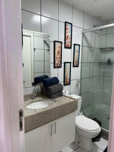 a bathroom with a sink and a toilet and a mirror at Flat Gran Solare Lençóis Barreirinhas in Barreirinhas