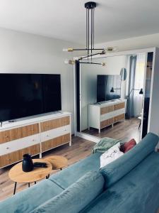 a living room with a blue couch and a flat screen tv at Apartament u Liska in Rumia