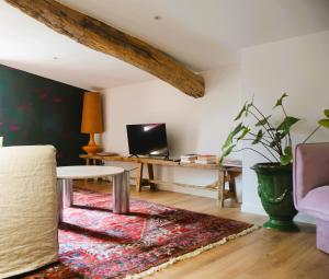 a living room with a table and a couch at Maison Groleau in Mombrier