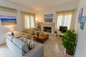 ein Wohnzimmer mit einem Sofa und einem Kamin in der Unterkunft Villa Mitsa in Kolios