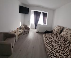 a living room with a leopard print couch and a table at Montain apartament in Brezoi