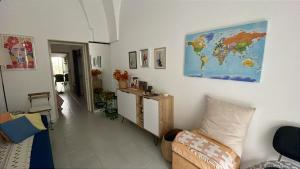 a living room with a couch and a map on the wall at Via Spani 13 in San Pietro Vernotico +4 photos